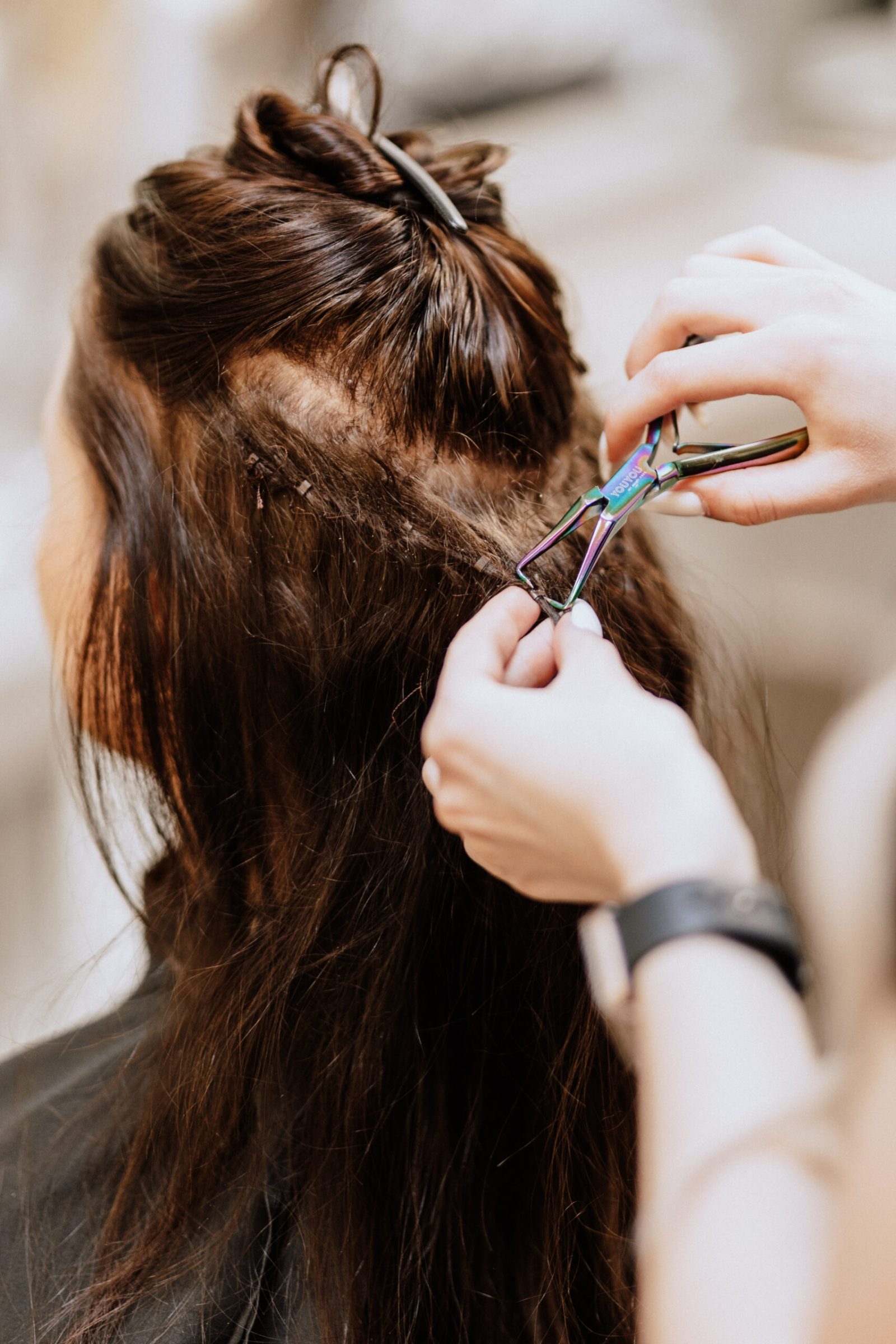 Einarbeiten von Extensions in dunklem Haar